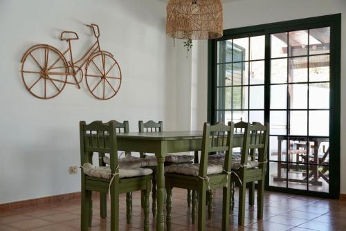 a dining room with a table and chairs and a bike on the wall at Casa Notas de Color Y Sal in Agaete