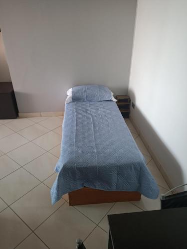 a bed with a blue blanket in a room at Appartamenti Lungomare Savona in Savona