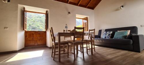 a living room with a table and a couch at Casa Rural Antigua Escuela II in Hermigua