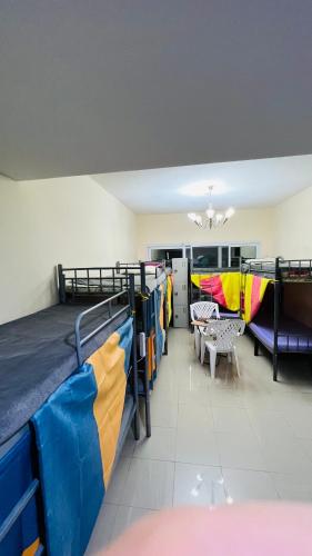 a room with two bunk beds and a table and chairs at Dubai Star Hostel in Dubai