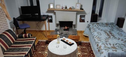 a living room with a bed and a fire place at Charlami's Mansion -Παραδοσιακό Πέτρινο Σπίτι με Τζάκι και Πανοραμική Θέα in Polýdroson