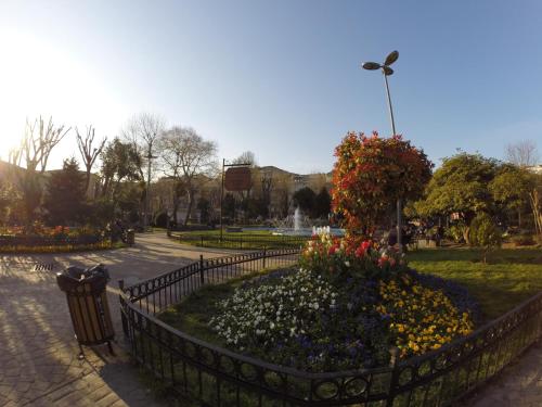a park with a fence and flowers and a fountain at Meydan Suites in Istanbul