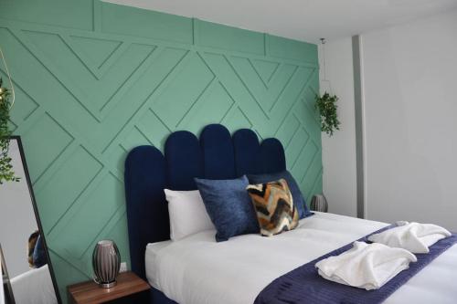 ミルトン・キーンズにあるStunning 2 bedroom aptの青と緑の壁のベッドルーム1室、ベッド1台が備わります。