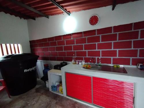 a kitchen with a sink and a red brick wall at Cabaña Isabella in San Bernardo del Viento