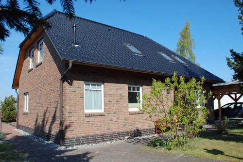 a brown brick house with a black roof at Ferienhaus mit Terrasse am Heideweg in Baabe