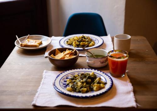 a wooden table with plates of food and a drink at Hotel Casa Pereyra in Oaxaca City