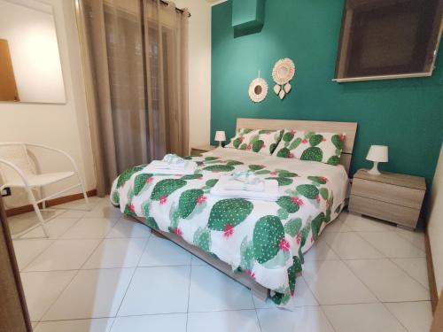 een slaapkamer met een bed en een groene muur bij Dolce Casa Taormina in Taormina