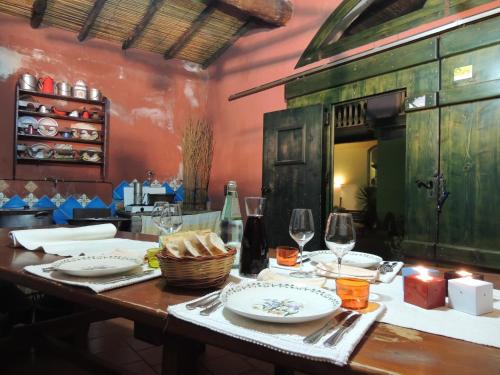 a table with plates and wine glasses on it at Hotel Su Lithu in Bitti
