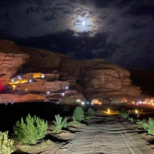 a night view of a mountain with a full moon at orbit camp 2 in Wadi Rum