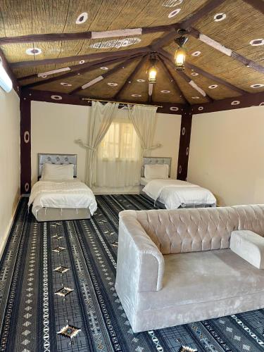 una sala de estar con dos camas y un sofá en شقق السودة هاوس, en Sawda