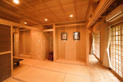 a large room with wooden walls and a hallway with windows at かたあきの里 in Miyako Island