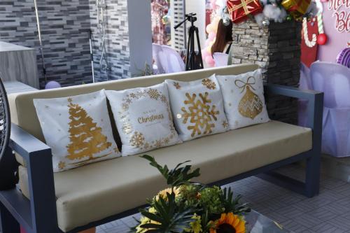 a bench in a store with christmas pillows on it at Rowena's River Resort in Nalsian