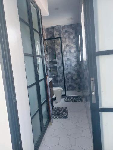a bathroom with a toilet and a glass door at Rowena's River Resort in Nalsian