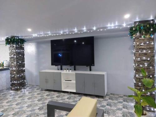 a living room with a flat screen tv on a wall at Rowena's River Resort in Nalsian