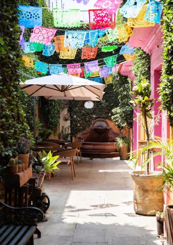 an outdoor patio with an umbrella and a bench at Hotel Casa Pereyra in Oaxaca City
