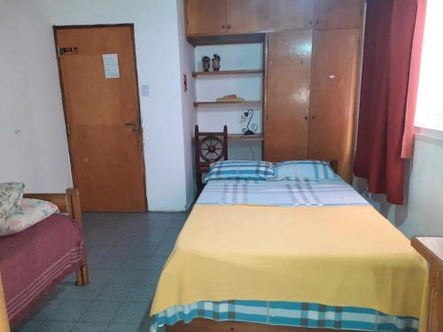1 dormitorio con 1 cama con manta amarilla en Monoambiente céntrico en Posadas