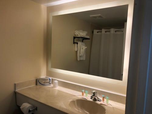 La salle de bains est pourvue d'un lavabo et d'un grand miroir. dans l'établissement Gazebo Inn Oceanfront, à Myrtle Beach