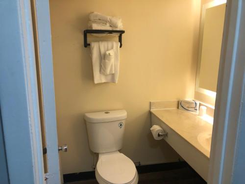a bathroom with a toilet and a sink with towels at Gazebo Inn Oceanfront in Myrtle Beach