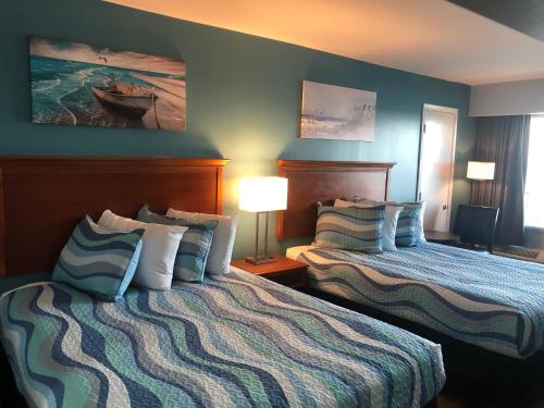 a hotel room with two beds and two lamps at Gazebo Inn Oceanfront in Myrtle Beach