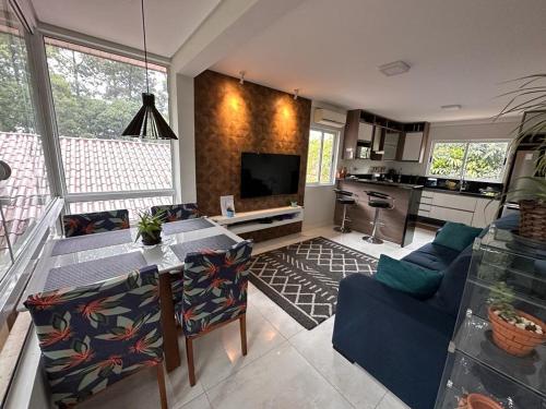 a living room with a couch and a table and a kitchen at Charming Home 2 min. from Barigui Park in Curitiba
