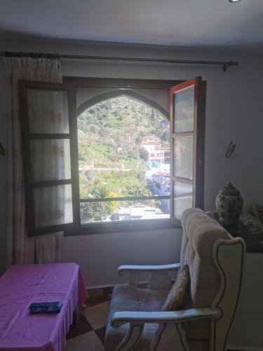 a room with a window and a couch and a table at Cascadas al Onsar Chefchauen in Chefchaouen