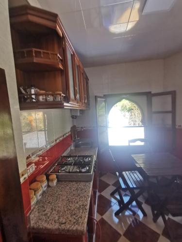 a kitchen with a stove and a table in it at Cascadas al Onsar Chefchauen in Chefchaouen