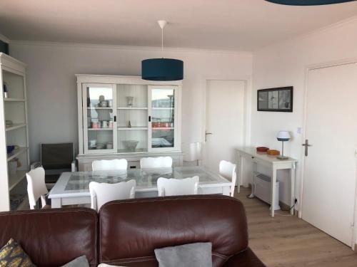 un salon avec un canapé, une table et des chaises dans l'établissement LES BALCONS ROUGES - FACE MER, à Sainte-Cécile-Plage