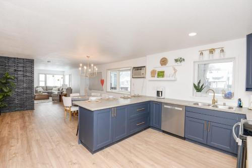 eine Küche mit blauen Schränken und ein Wohnzimmer in der Unterkunft NEW Remodeled Townhome in Central Fargo in Fargo