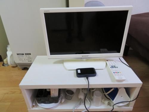 un monitor de ordenador sentado en la parte superior de un escritorio blanco en 直前半額プライベート個室トイレバスタブ付民泊札幌市中心部でシンプルな滞在, en Sapporo