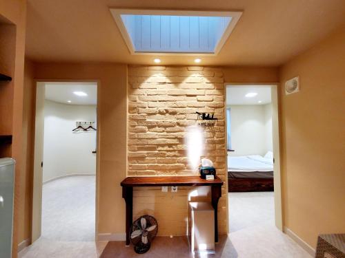 a room with a stone wall and a skylight at Jeonju Hanok Little Prince in Jeonju