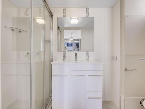 ein weißes Bad mit einem Waschbecken und einer Dusche in der Unterkunft Blue Horizon Unit 1 Bulcock Beach QLD in Caloundra