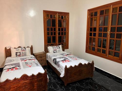 a bedroom with two beds and a window at villa OUSSAMA in Marrakech