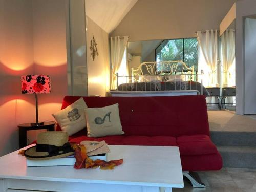 a living room with a red couch and a table at Romance Chalet on Gallery Walk with Spa, Fireplace, WiFi & Netflix in Mount Tamborine