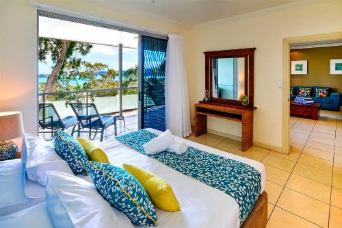 a bedroom with a bed and a balcony at Blue Water Views Apartments in Hamilton Island