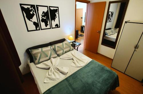 um quarto com uma cama num quarto com um espelho em Apto Executivo Ravena em Campo Grande