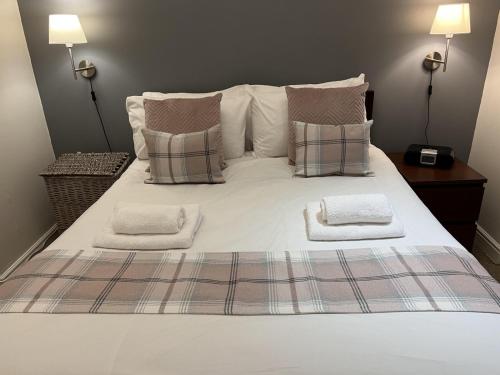 a large white bed with pillows and two towels on it at Sunshine On Leith Apartment in Edinburgh