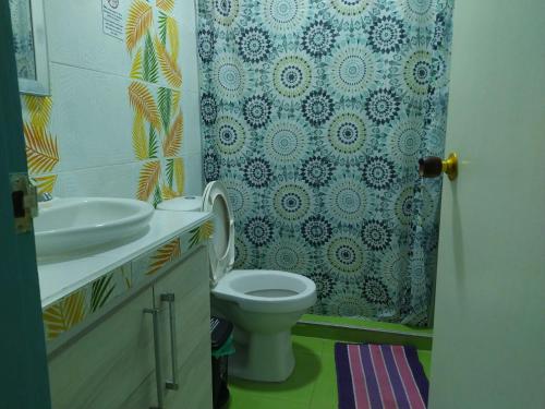 y baño con aseo, lavamanos y cortina de ducha. en Apartamentos AJ place 2 en San Andrés