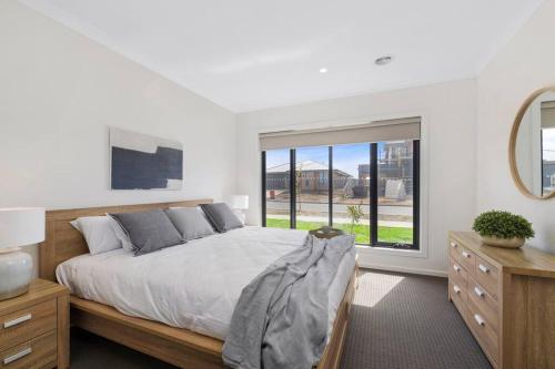 a bedroom with a bed and a large window at Winter Valley Retreat - Palatial Pad in the Valley! in Alfredton