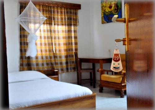 a bedroom with two beds and a table and a chair at Hotel Aurore Lomé in Lomé