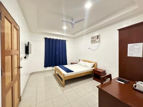 a bedroom with a bed and a blue curtain at CafeMare Rooms in Bantayan Island