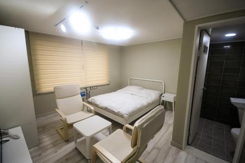 um quarto de hospital com uma cama e um chuveiro em Bluehum Guest house em Incheon