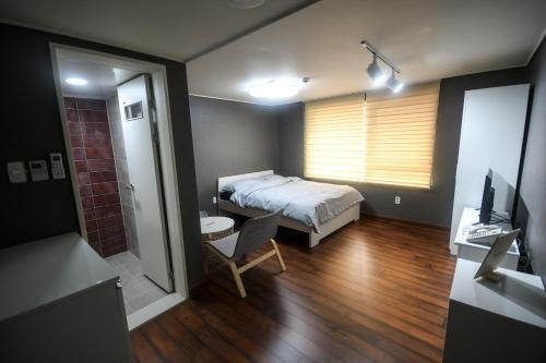 a bedroom with a bed and a table and a chair at Bluehum Guest house in Incheon