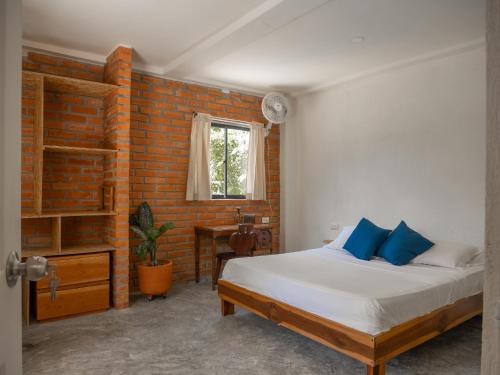 - une chambre avec un lit et un mur en briques dans l'établissement Kallpa B&B, à Palomino