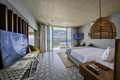 a bedroom with a bed and a view of the ocean at Burgos Reef Boutique Resort in Padre Burgos