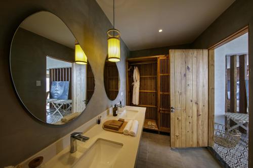 a bathroom with a tub and a large mirror at Burgos Reef Boutique Resort in Padre Burgos