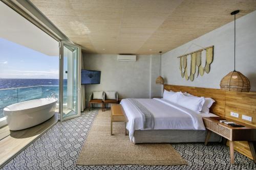 - une chambre avec une baignoire, un lit et une salle de bains dans l'établissement Burgos Reef Boutique Resort, 