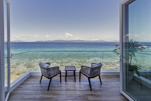 a balcony with a table and chairs and the ocean at Burgos Reef Boutique Resort in Padre Burgos