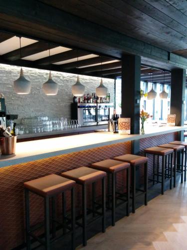 a bar with brown stools in a restaurant at Hotel Bieze in Borger
