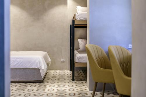 a bedroom with a bed and two chairs in a room at Burgos Reef Boutique Resort in Padre Burgos