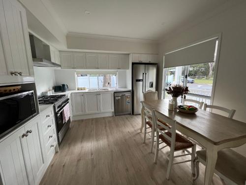 a kitchen with a table and a dining room at Hunter Valley D'Vine Stay II in Nulkaba